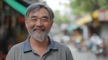 Middle-aged man smiling warmly, standing outdoors with blurred street background photo