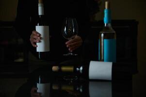 Dark mood scene featuring wine bottles and empty glasses on a table photo