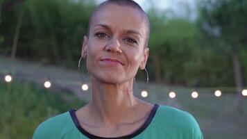 Portrait of a woman with shaved head smiling happy looking at camera in slow motion. video