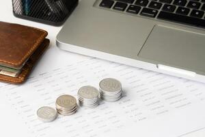 stack of grow coin on the table with laptop and wallet photo