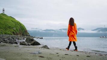 Solitude And Unity With Nature, Lonely Woman Traveler Walking On Coastline Near Cape With Lighthouse video