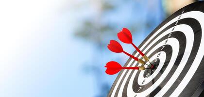 Three dart arrow on target with blue sky background photo
