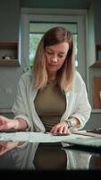 Woman calculating domestic bills and counting remaining money, sitting at kitchen table and planning personal finance. Concept of rising costs in households video