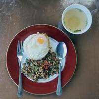 minced pork with basil and fried egg top on cooked rice photo