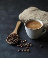 cup of coffee and some brown coffee beans in the background photo