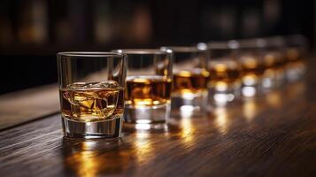 line of whiskey glass on wooden bar photo