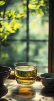 glass cup of green tea near window photo