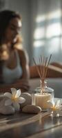 A reed diffuser, candles, and rocks on the table photo
