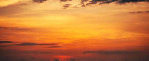 Panorama with orange sunset in cloudy sky with clouds. Background with sky at sunrise photo