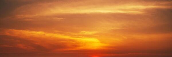 Panorama with orange sunset in cloudy sky with clouds. Background with sky at sunrise photo