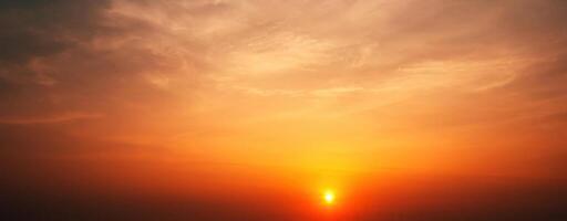 Panorama with an orange sunset and sun in cloudy sky with clouds. Background with sky at sunrise photo