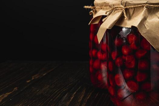 Homemade cherry and raspberry jam in large jars with rustic decor photo