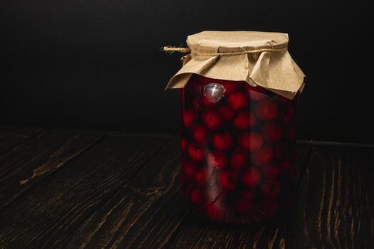 Homemade cherry and raspberry jam in large jar with simple design photo
