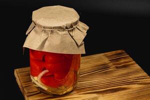 Homemade pickled tomatoes and sweet peppers preserved in jars photo