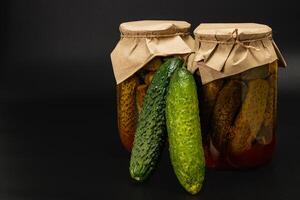Homemade canned pickled cucumbers and fresh vegetables on display photo