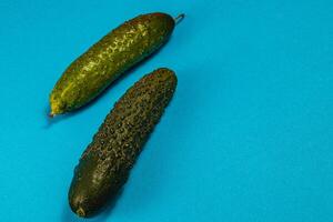 Fresh cucumbers displayed on vibrant blue background for food presentation photo