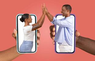 African American couple is connecting through their smartphones, showcasing their love and affection. They appear engaged in a joyful exchange, representing a modern relationship in the digital age. photo