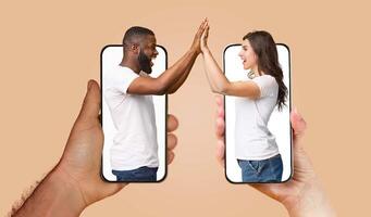 A couple engages with each other using smartphones, their hands touching through screens, showcasing modern communication in their relationship. photo