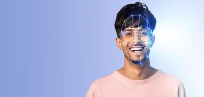 A young man smiles while his face is scanned by advanced facial recognition technology. The background is plain, highlighting the innovative aspect of identification through modern methods. photo