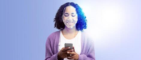 A person is smiling while holding a smartphone in front of them. Their face is illuminated by a digital display, showcasing advanced face recognition technology in use. photo