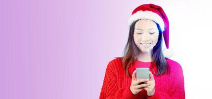 A person wearing a Santa hat smiles while using a smartphone. The focus is on the facial recognition technology, showcasing the joy of connecting during the festive season. photo