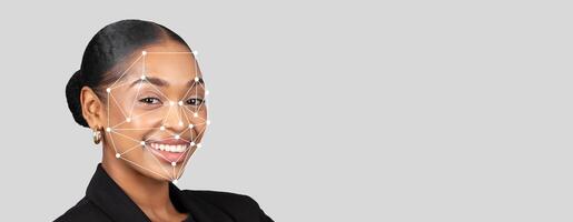 A smiling individual is featured against a neutral background, showcasing facial recognition technology. The overlay of lines emphasizes key facial points for identification purposes. photo