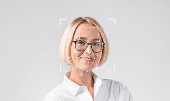 A woman smiles while being analyzed by facial recognition technology. This image highlights advancements in ID technology and how it is used for identification purposes in various fields. photo