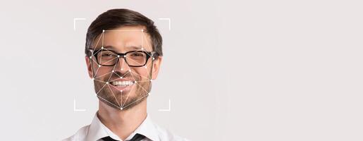 A smiling man with glasses is featured prominently on a blank background, highlighting facial recognition technology. His expression conveys friendliness in a professional context. photo