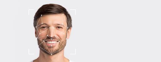 A smiling individual is shown against a blank background, highlighted by facial recognition technology dots. This setup illustrates innovative identification methods in a minimalist space. photo