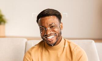 A young man smiles while facial recognition technology analyzes his features. The setting is minimalistic, with neutral colors and soft lighting, indicating a contemporary indoor environment. photo