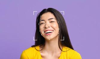 A young woman smiles brightly against a purple backdrop, with facial recognition markers overlaying her face. This technology highlights the emerging field of identity verification and analysis. photo