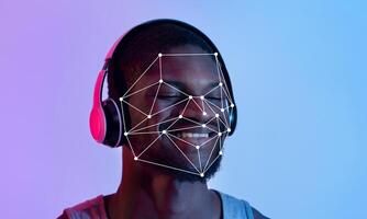 A person enjoys music through headphones while facial recognition technology maps facial features for identification. The vibrant background adds a modern touch to the experience. photo