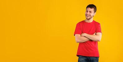 Portrait of handsome bearded guy smiling and looking away at copy space isolated over blue studio background. Happy caucasian man with happy facial expression posing with folded arms photo