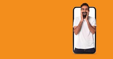 A person expresses joy and surprise as they interact with a smartphone application. photo