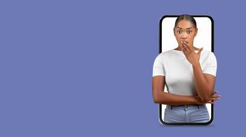 A person with a surprised expression stands in front of a smartphone displaying their image. They appear engaged in communication while reacting to unexpected online content. photo