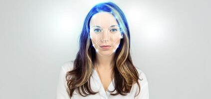 A woman stands with a neutral expression, as advanced facial recognition technology scans her features. The backdrop is a plain white space, emphasizing the futuristic aspect of identification. photo