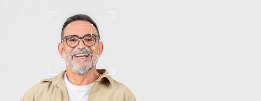 A smiling older man with glasses faces the camera, showcasing advanced facial recognition technology. The background is plain, emphasizing the identification process in a clean, isolated space. photo