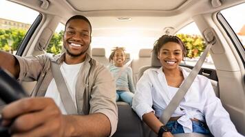 Black Parents And Daughter Posing Riding New Car Smiling To Camera Enjoying Road Trip. Family Having Vacation Traveling Together By Auto. Automobile Purchase Concept. Selective Focus photo