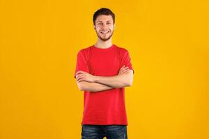 Portrait of happy bearded guy smiling, looking at camera and posing with folded arms isolated over blue studio background. Confident caucasian man crossing hands, expressing positive emotions photo