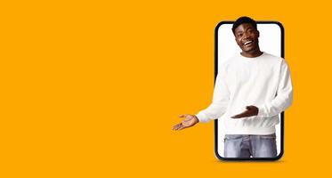 A person is engaged in communication using a smartphone with a large screen. Bright orange background emphasizes the interaction, highlighting modern technology and social media applications. photo