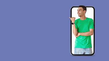 A person is pointing towards their smartphone, showcasing a large screen displaying social media applications. The setting features an isolated background that emphasizes the technology involved. photo