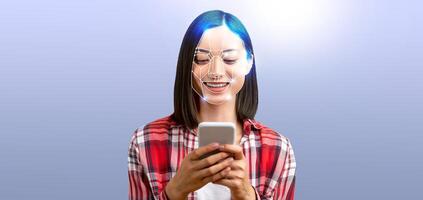 A woman smiles as she interacts with her smartphone, utilizing advanced facial recognition features. The background is simple and emphasizes the technology in focus. photo