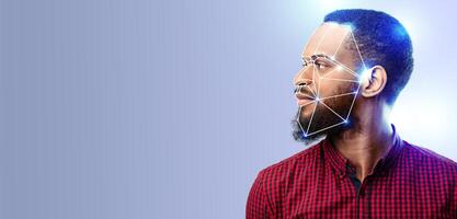 A man is shown in profile as facial recognition technology scans his features. The background is a smooth gradient, emphasizing the advanced identification process and modern tech. photo