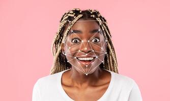 A joyful individual displays a wide smile while facial recognition technology maps their features. The backdrop is a soft pink, creating an engaging and lively atmosphere. photo