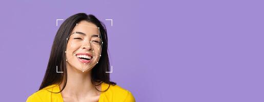 A woman with long dark hair is smiling brightly against a purple backdrop. Facial recognition technology tracks her features for identification, showcasing a blend of emotion and technology. photo