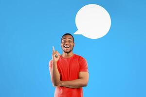 Great Idea. Excited Black Guy Pointing Finger Up Posing With Blank Speech Bubble Above Head Smiling To Camera Standing Over Blue Studio Background. Eureka Moment, Inspiration Concept. Square photo