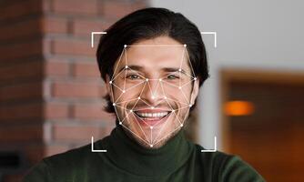 A man smiles as facial recognition technology scans his features. The background is softly blurred, emphasizing the subject's joyful expression and the innovative tech overlay. photo