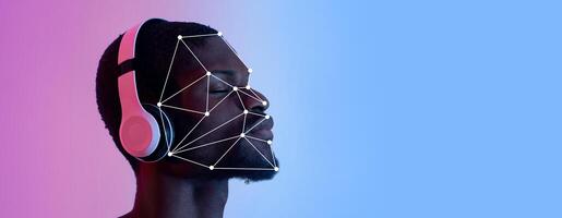 A man with headphones enjoys music while facial recognition technology overlays his face. The background features a blend of colors, providing a clear focus on the subject's expression and the tech. photo