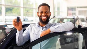 Car Credit Concept. Happy Black Male With Car Keys In hand Posing Near New Automobile, Cheerful African American Man Leaning On Automobile Door And Smiling At Camera, Closeup Shot With Free Space photo