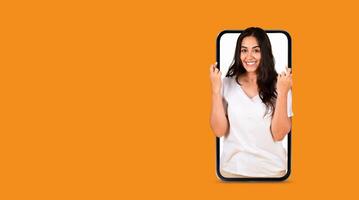A person is joyfully expressing excitement while holding a smartphone in front of them. photo